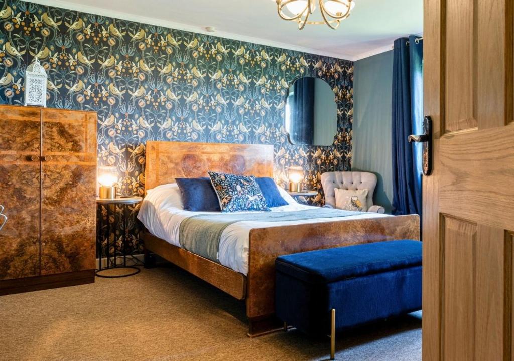 a bedroom with a bed and a blue wall at Gorgeous Rural 4 Bed Farm Cottage - With Hot Tub! in Norton Saint Philip