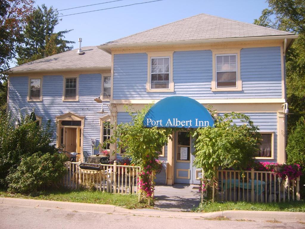 una casa azul con un cartel de posada de alerta portuaria delante de ella en Port Albert Inn and Cottages, en Port Albert