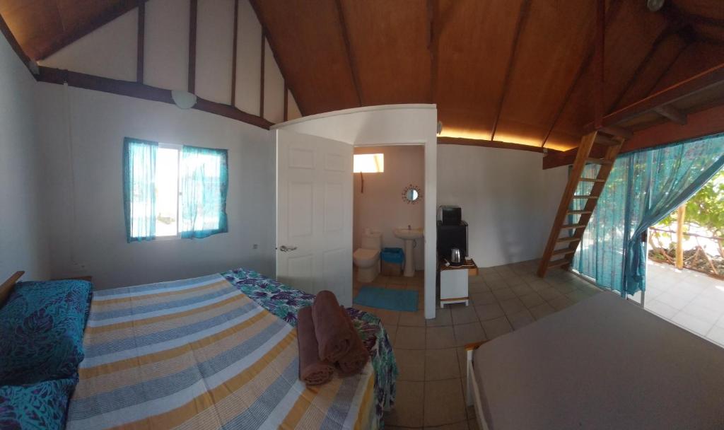 una camera da letto con un letto e una scala in una stanza di Vaimoe Lodge Tiputa a Tiputa