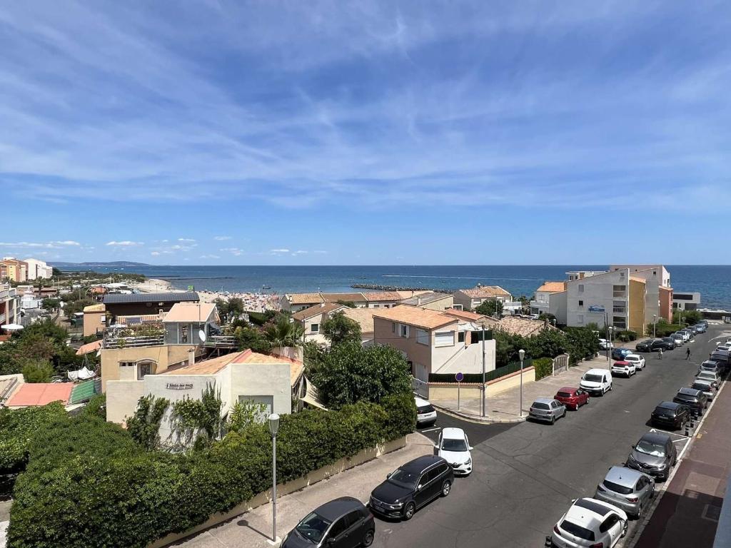 une rue de la ville avec des voitures garées sur le côté de la route dans l'établissement Studio avec Piscine, Parking, Clim, Plage à 50m - FR-1-702-69, au Cap d'Agde