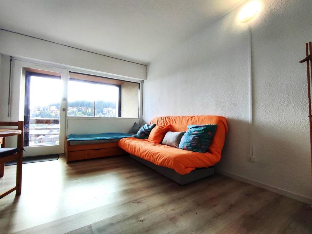un canapé orange dans une pièce avec une fenêtre dans l'établissement Studio 4 pers. confort au pied des pistes - FR-1-592-73, à Bolquère-Pyrénées 2000