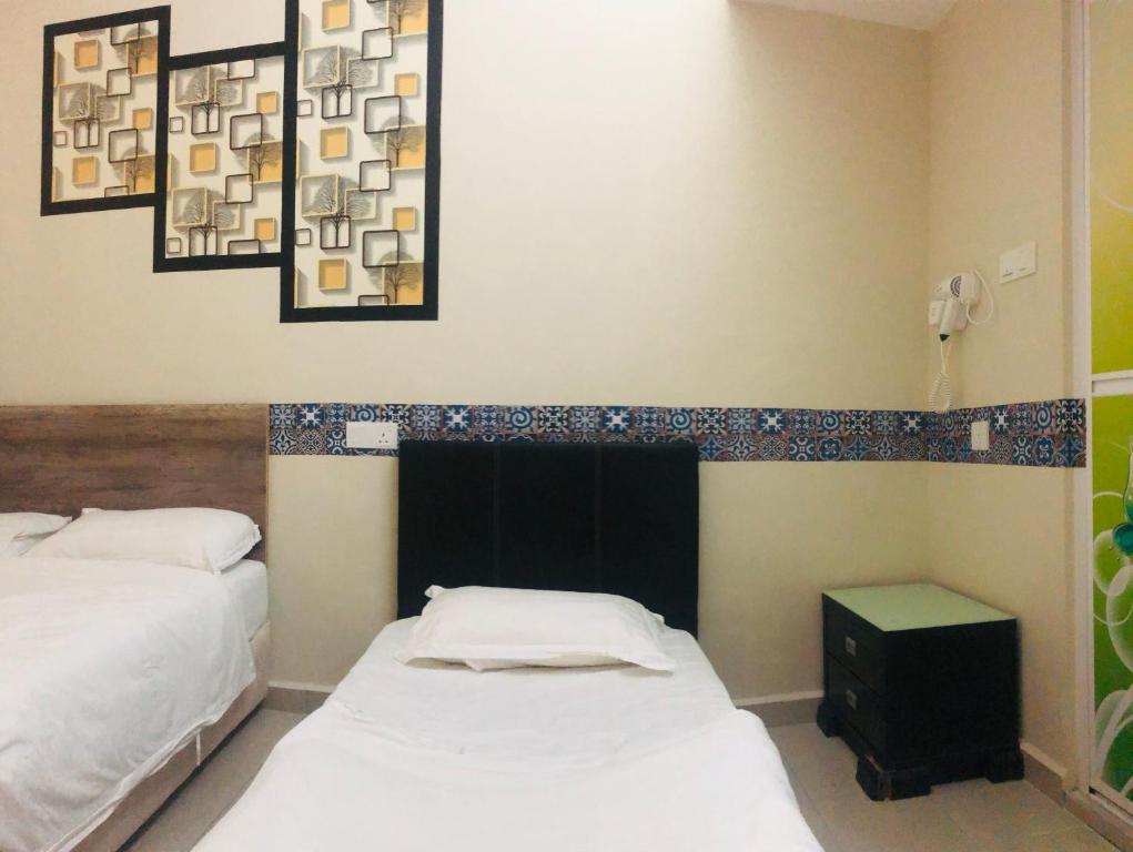 a bedroom with two beds and a mirror at Green Live 201 in Melaka