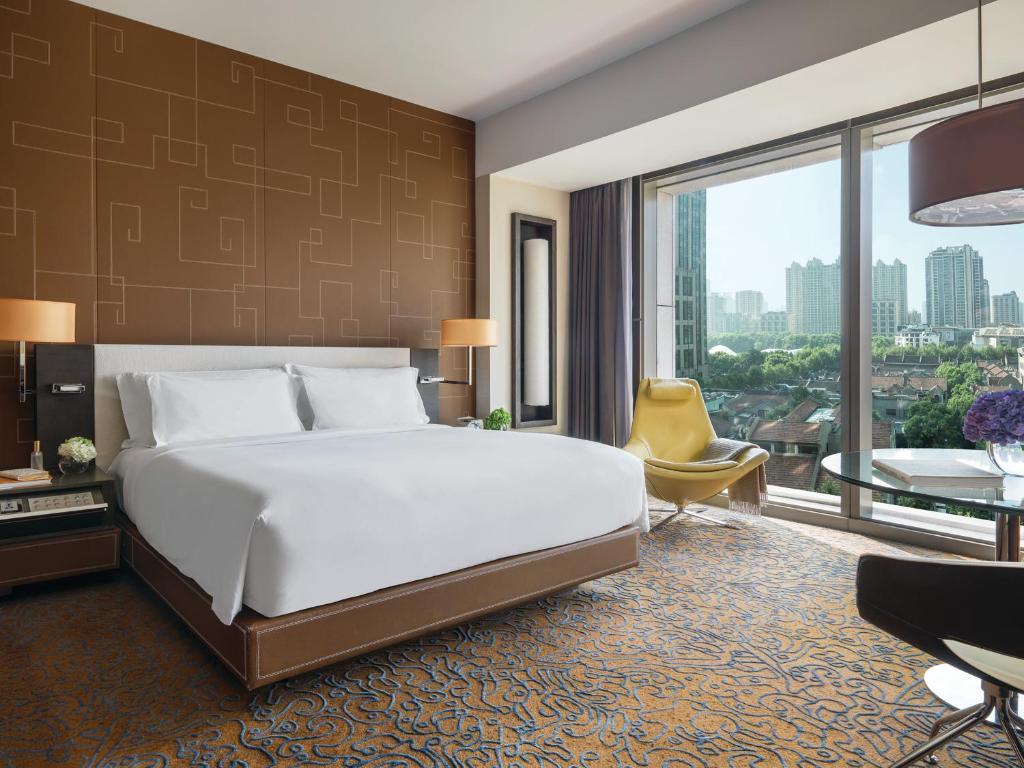 a bedroom with a large bed and a large window at The Langham, Shanghai, Xintiandi in Shanghai