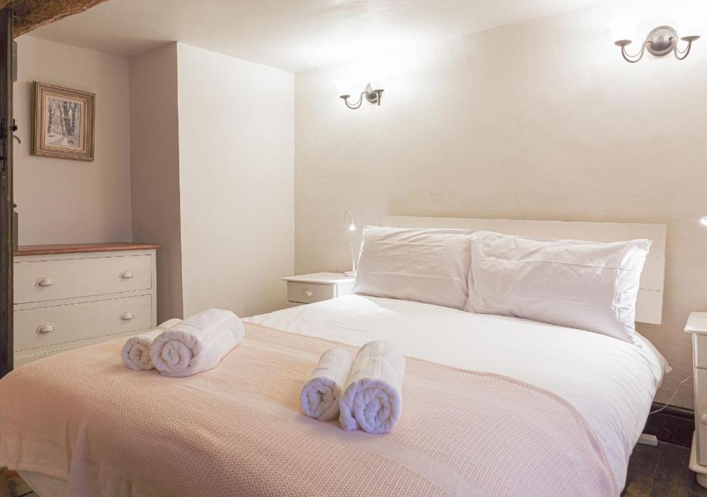 a bedroom with a bed with towels on it at Honeypot Cottage - Charming Bolthole in Stow! in Stow on the Wold
