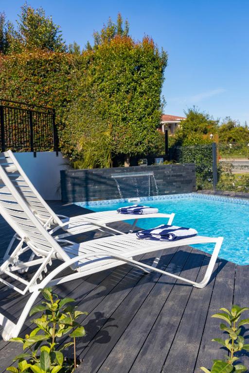a pair of lounge chairs sitting next to a swimming pool at Cloverleigh Guest House in Wilderness