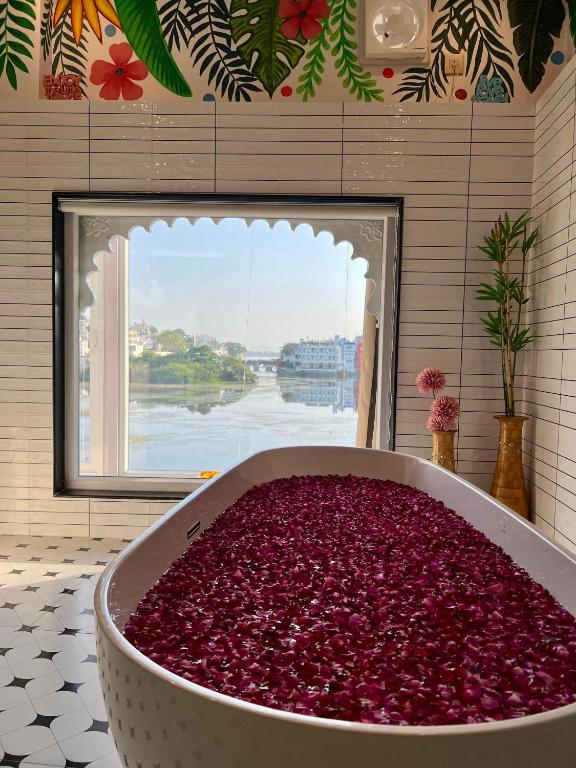 a large tub filled with red cranberries in a bathroom at Natural Lake View Hotel in Udaipur
