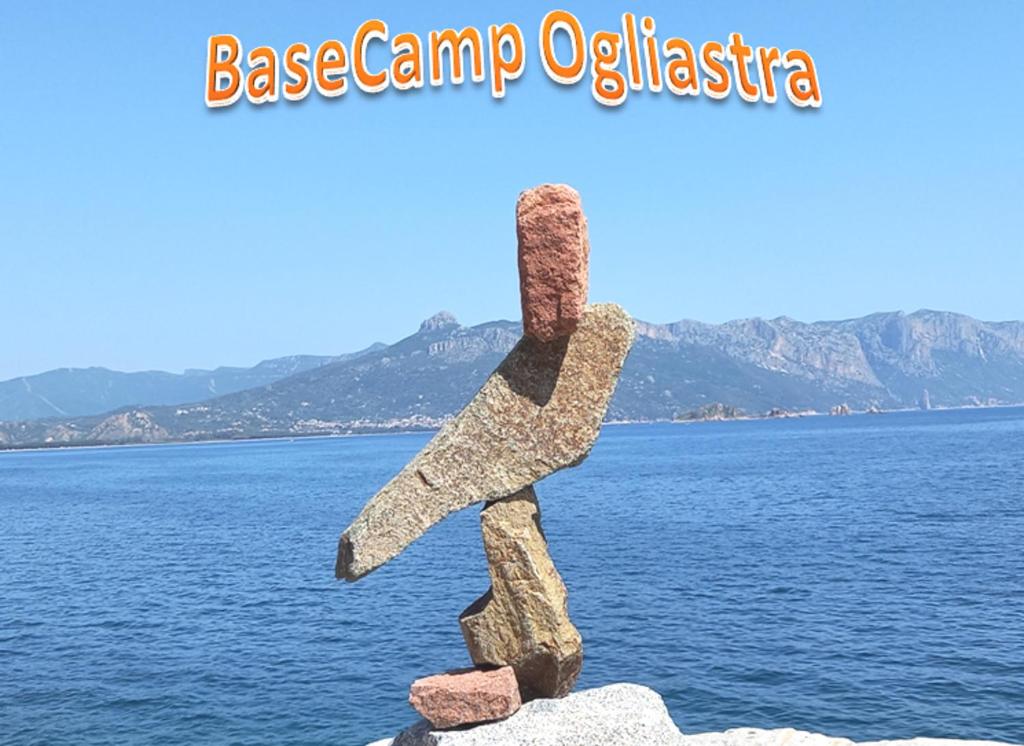 una statua di roccia davanti a un corpo d'acqua di BaseCamp Ogliastra - House a Santa Maria Navarrese