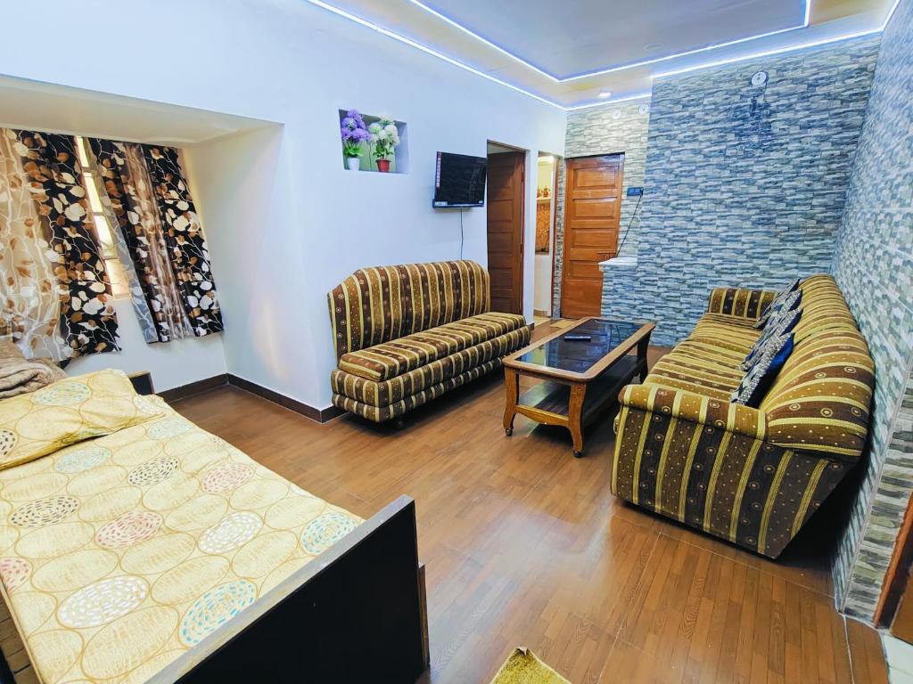 a living room with a bed and a couch and chairs at Kiara Home stays in Varanasi