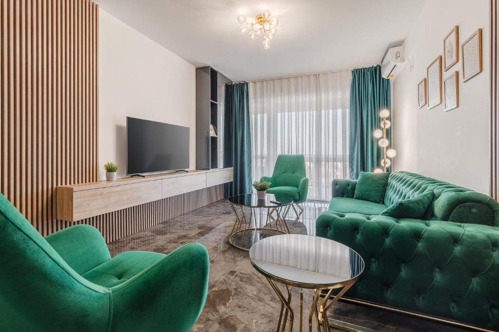 a living room with green furniture and a tv at Sunset Flat in Oradea
