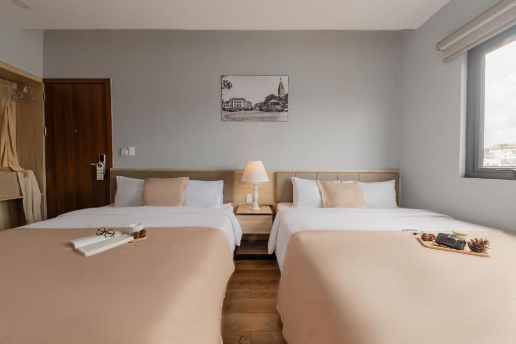 Postel nebo postele na pokoji v ubytování Gia Nguyễn Hotel Dalat