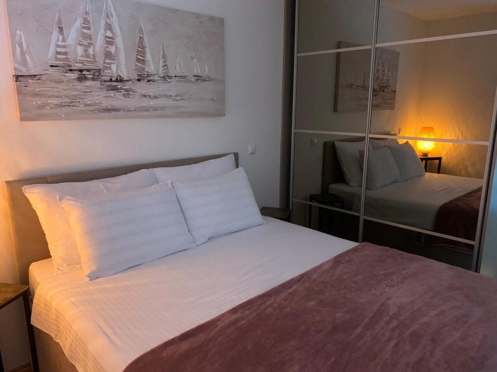 una piccola camera da letto con un letto e uno specchio di Remi a Slavonski Brod