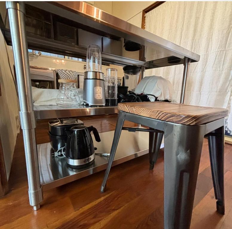 a table and a shelf with a coffee maker on it at 繁華街まで徒歩10分の好立地 観光や食事を楽しむことができます in Amami