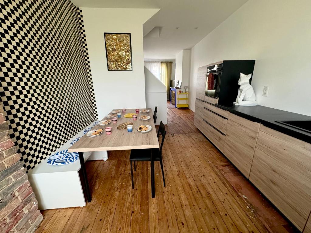 a dining room with a table and a cat on the counter at Maison 3 étages en centre-ville in Laon