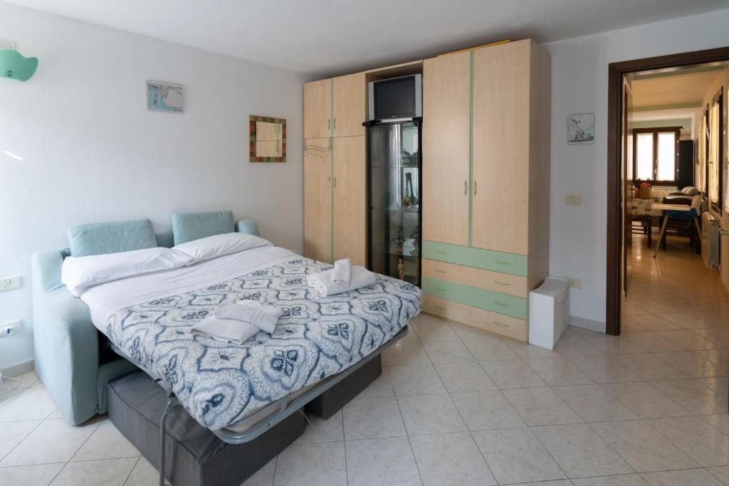 a bedroom with a large bed and a kitchen at Risi & Bisi - il nostro rifugio in Chioggia