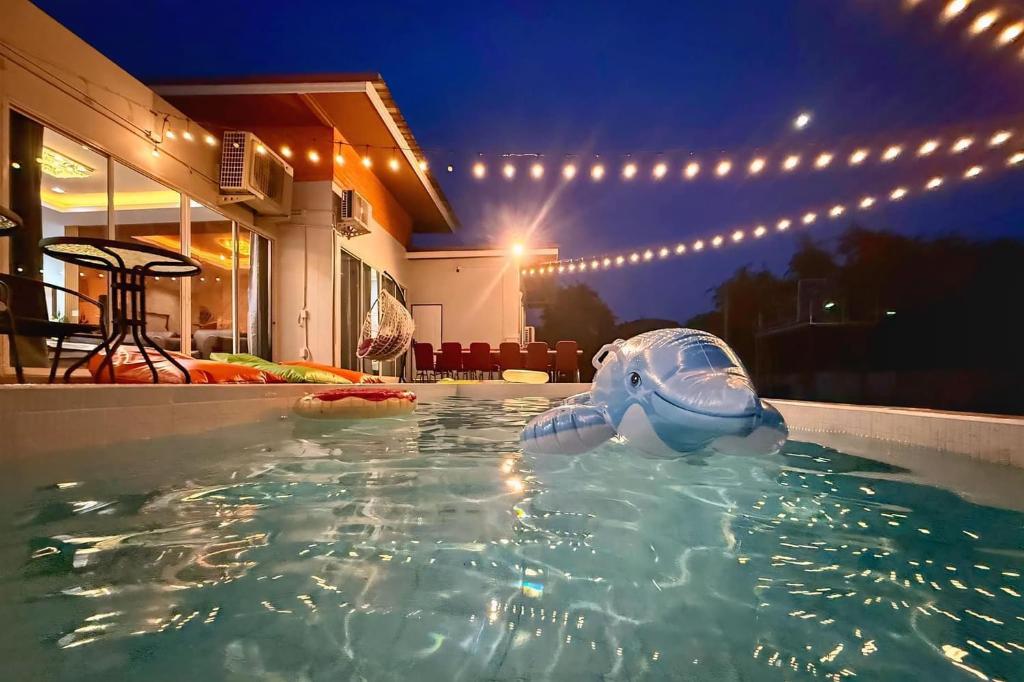 ein aufblasbarer Elefant in einem Schwimmbad bei Nacht in der Unterkunft Anny poolvilla 5 bedroom ATV free in Ban Lum Phli
