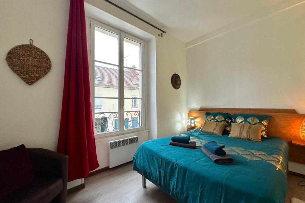 une chambre avec un lit avec des draps bleus et une fenêtre dans l'établissement Cozy apartment in the heart of Chantilly!, à Chantilly