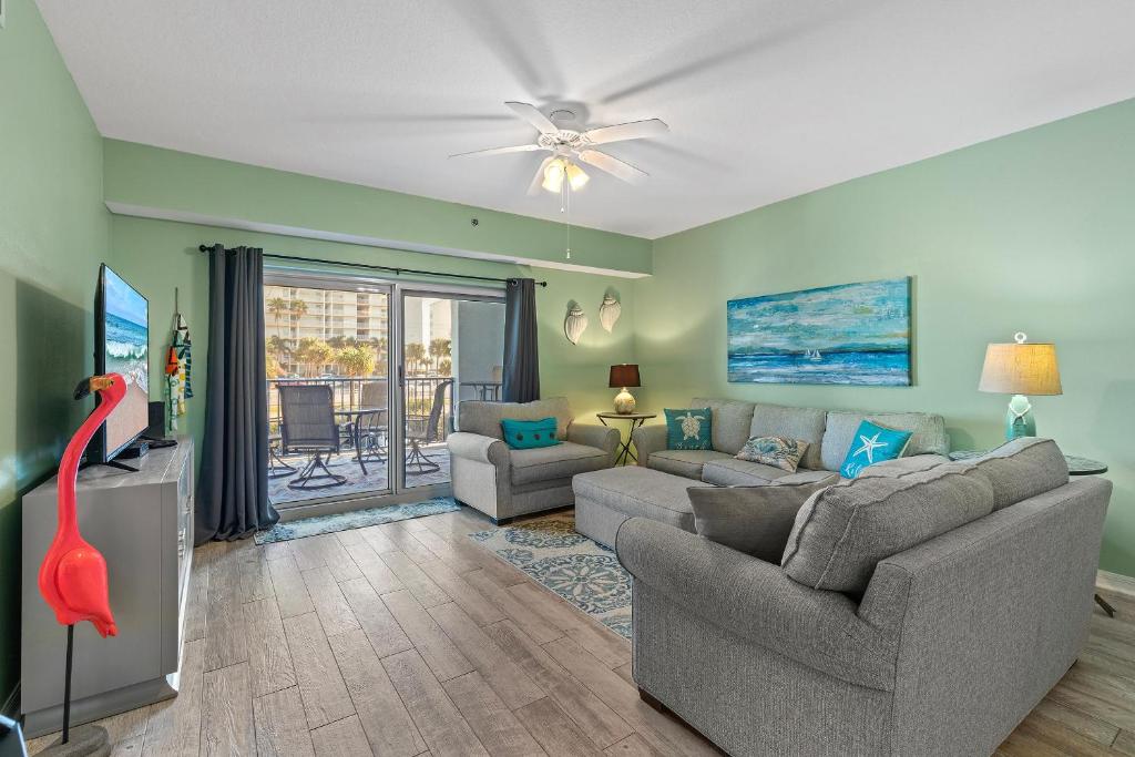 a living room with a couch and a flat screen tv at Oceanwalk 2-202 in New Smyrna Beach