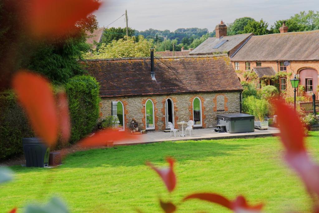 una vecchia casa in pietra con un cortile e un cortile di The Hornbill at Home Farm Shropshire a Shrewsbury