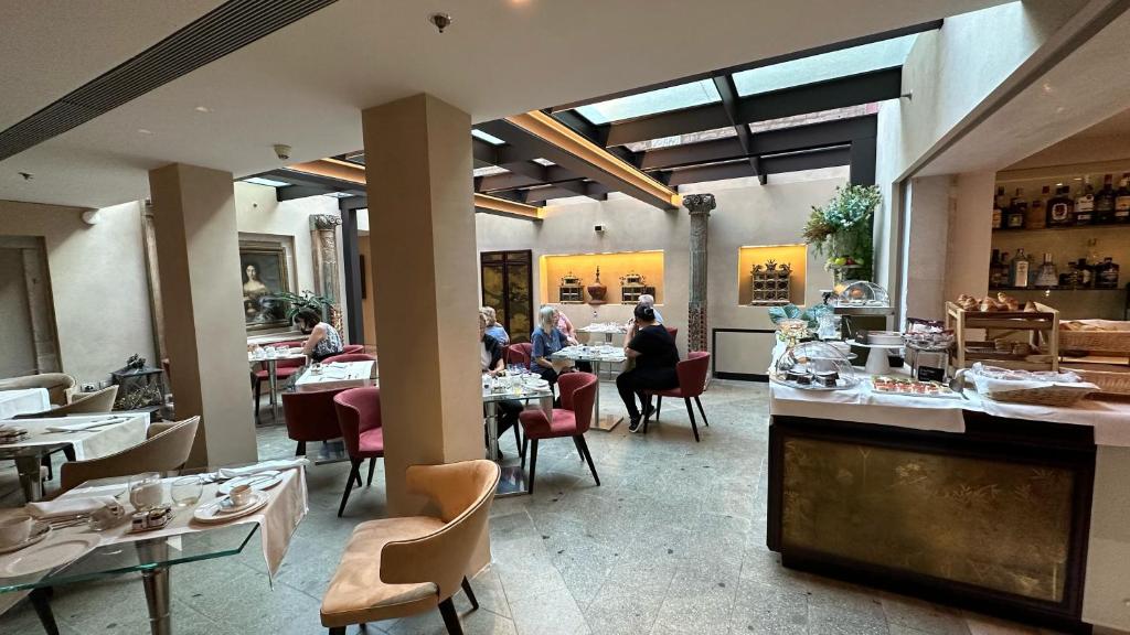 a restaurant with people sitting at tables in a room at Ca' Nigra Lagoon Resort Adults Only in Venice