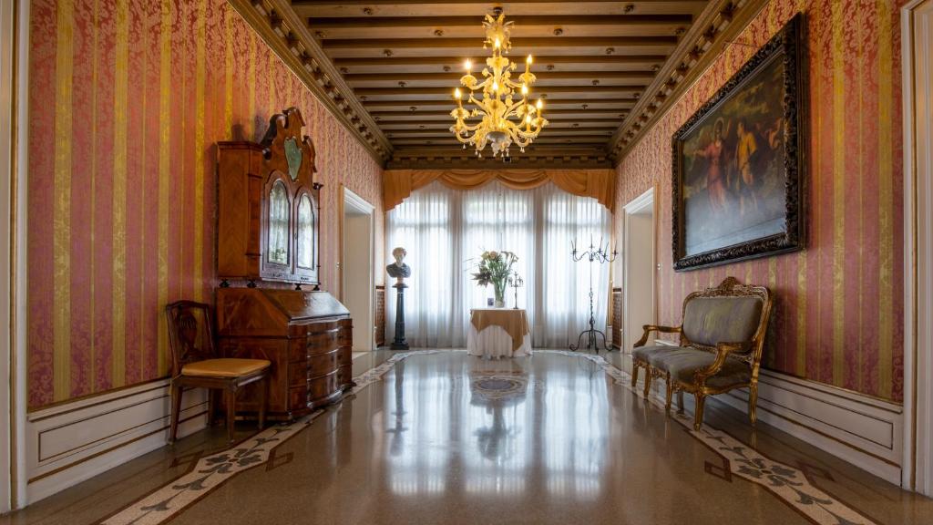 a living room with a chandelier and a table and chairs at Ca' Nigra Lagoon Resort Adults Only in Venice