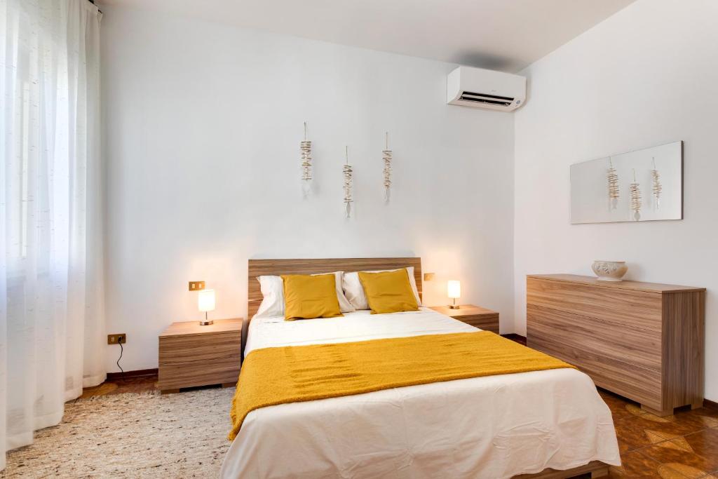 a bedroom with a large bed with yellow pillows at Casariosa, centro Rimini in Rimini