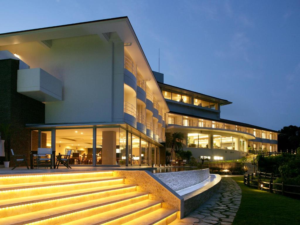 a large building with stairs in front of it at Hotel Hamahigashima Resort in Uruma