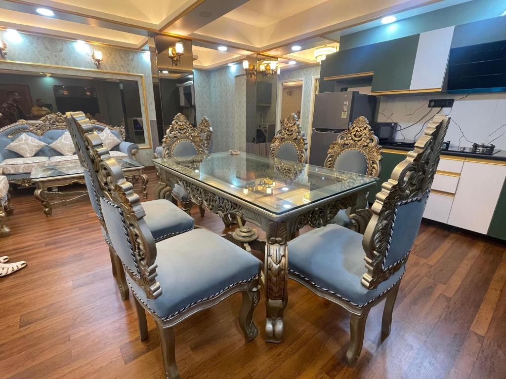 een eetkamer met een glazen tafel en stoelen bij Kamisama Boutique Stay in Vagator