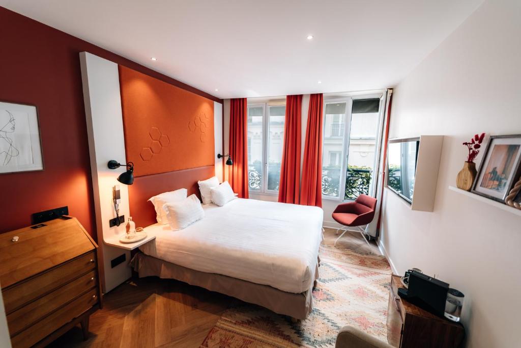 a hotel room with a bed and a desk at Hôtel Vendome Saint-Germain in Paris