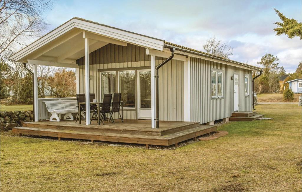 a tiny house with a porch and a deck at Two-Bedroom Holiday Home In Lottorp in Löttorp