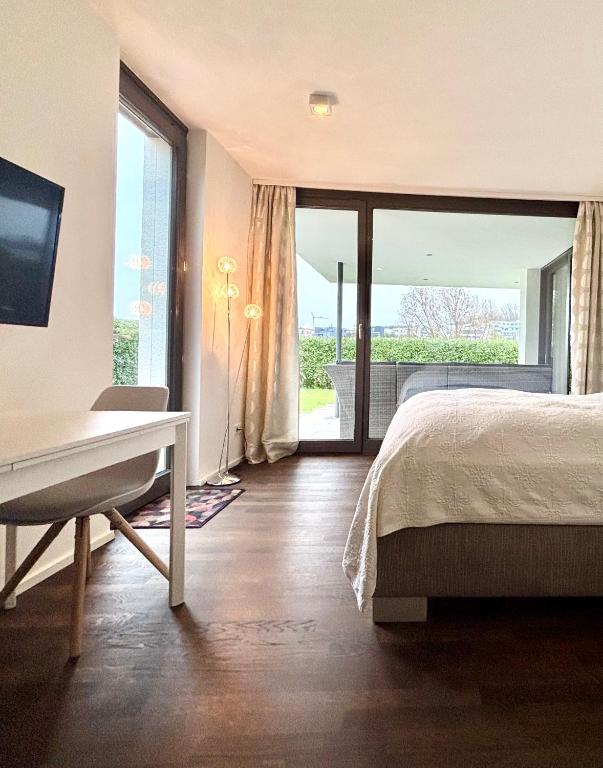 a bedroom with a bed and a desk and a window at Studio Apartment direkt am Phoenixsee in Dortmund