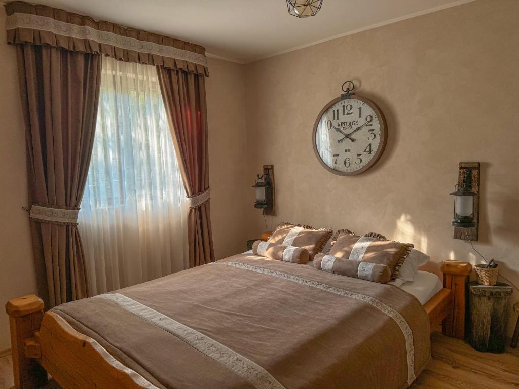 Malo SredišteにあるCasa Rustic 2のベッドルーム1室(ベッド1台、壁掛け時計付)