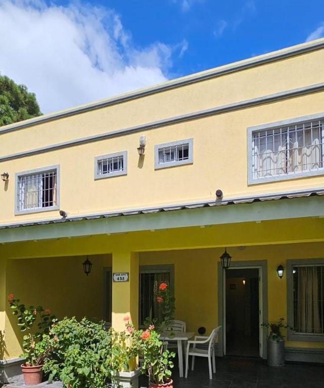 a yellow house with a table in front of it at Dúplex Resolana Apartamentos con Servicios in Valeria del Mar