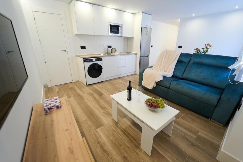 a living room with a blue couch and a table at 1ª planta C Apartamentos Juan Robledo Centro ciudad in Andújar