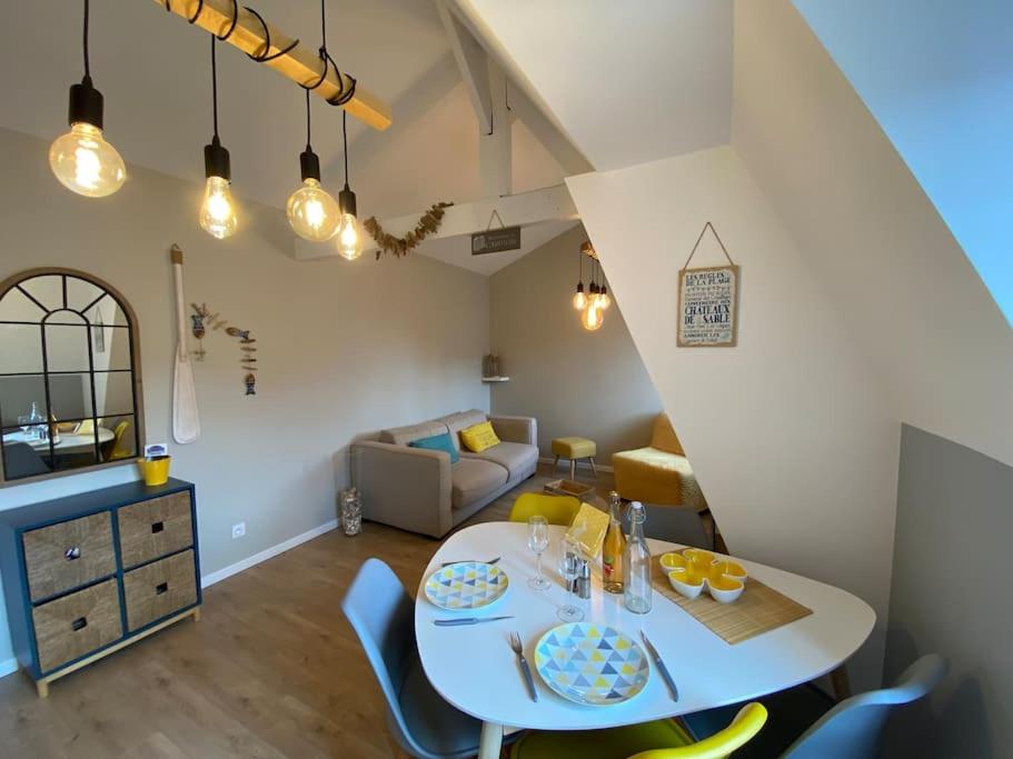 un salon avec une table et des chaises blanches dans l'établissement Armonid au coeur de Cabourg, à Cabourg