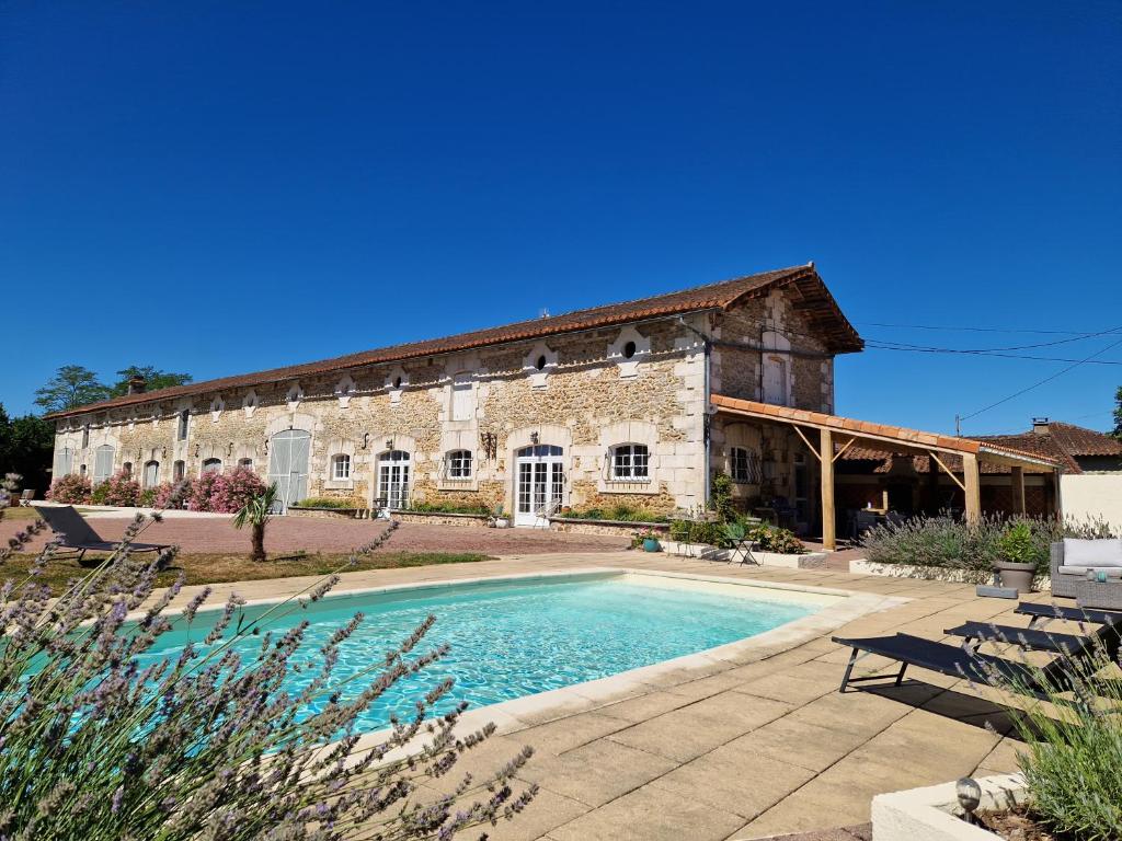 - un ancien bâtiment en pierre avec une piscine en face dans l'établissement Les Quintanes, à Suaux