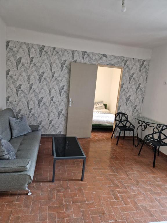 un soggiorno con un divano e un tavolo di Une chambre Salle de bain Wi-Fi a Bédarrides