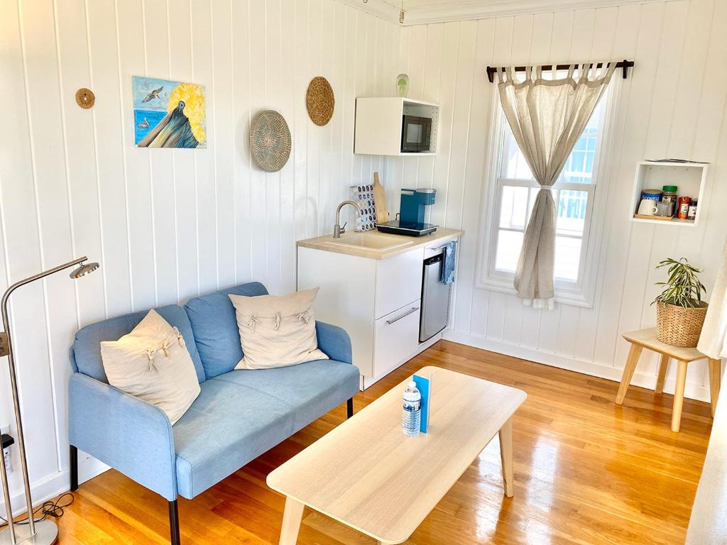 a living room with a blue couch and a table at Eleuthera Retreat - Private Villa & Cottages on pink sand beachfront in North Palmetto Point