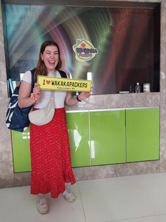 a woman holding a sign that reads im making pickles at WakakaPackers in Kuala Lumpur
