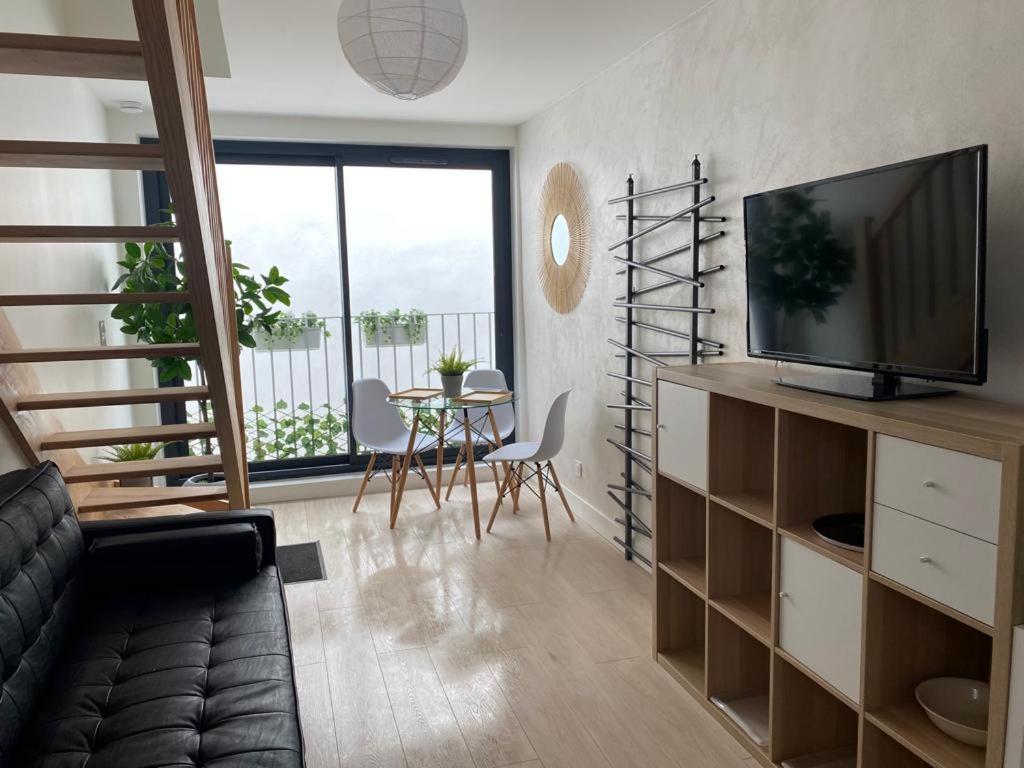 un salon avec un canapé, une télévision et une table dans l'établissement CENTRE HISTORIQUE avec GARAGE, à Bayonne