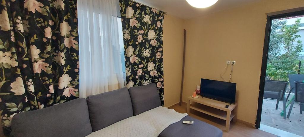 ein Wohnzimmer mit Sofa und Fernseher in der Unterkunft Airport Friendly House 3 in Artemida