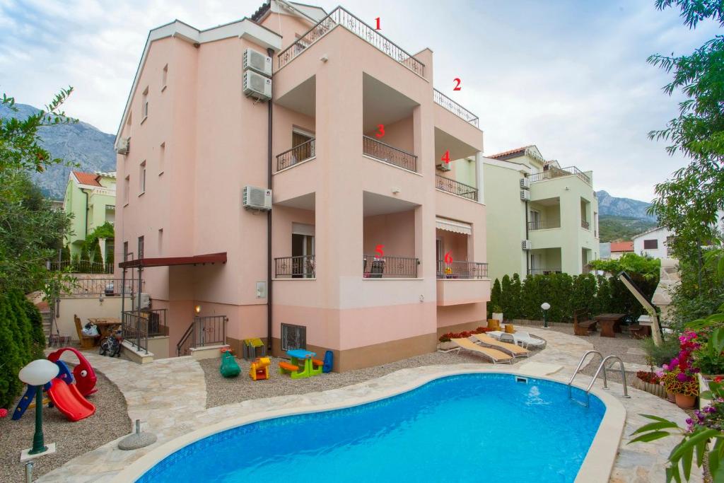 an apartment with a swimming pool in front of a building at Apartments Bojka in Promajna