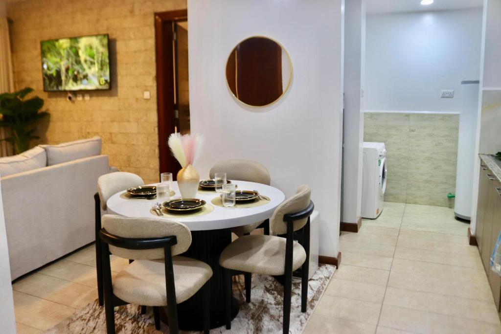 a dining room with a white table and chairs at Imagine Luxury Apartments in Nairobi
