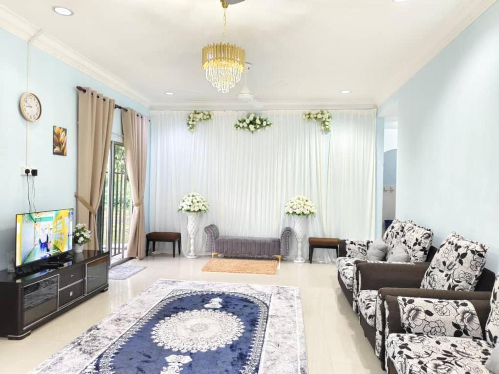 a living room with a couch and a tv at NASUHA HOMESTAY 2 TEMERLOH Semi-D House, 4 Bedroom, 2 Bathroom, 4 Unit Aircond, Njoy in Temerloh