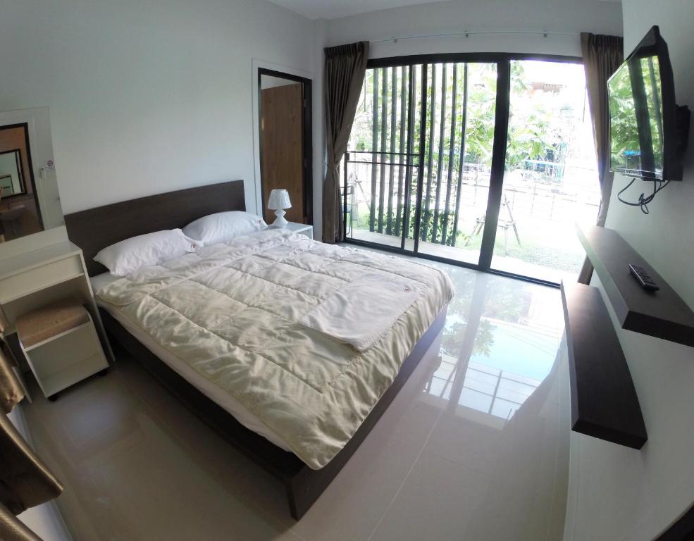 een slaapkamer met een groot bed en een groot raam bij Fairtex Residence Pattaya in Noord Pattaya