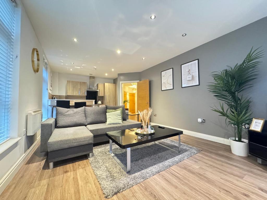 Hotel Modern TWO Bedroom Apartment Birmingham City Centre - 2 BATHROOMS - SLEEPS 6 GUESTS - FREE Underground Parking - FAST Speed Internet, a living room with a couch and a table at Modern TWO Bedroom Apartment Birmingham City Centre - 2 BATHROOMS - SLEEPS 6 GUESTS - FREE Underground Parking - FAST Speed Internet in Birmingham