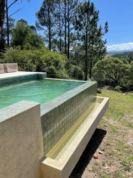 una piscina con agua verde en un patio en Casareartesesok, en Los Reartes