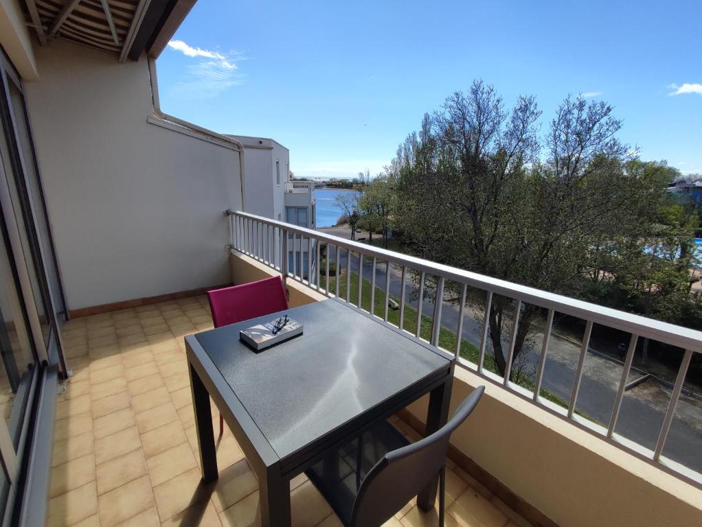 un balcon avec une table et des chaises et une vue dans l'établissement Cap d'Agde duplex l'Olivier vue mer 5 à 6 pers, au Cap d'Agde