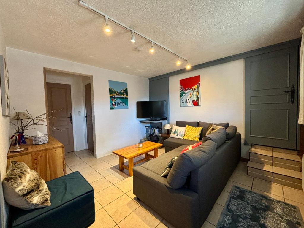 un salon avec un canapé et une table dans l'établissement Charmant T3 proche du centre de Châtel - Multipass inclu, à Châtel