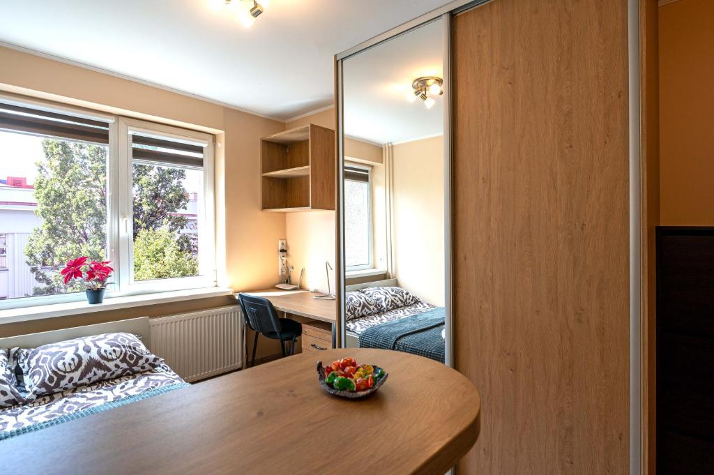 a room with a table and a bed and a mirror at Studio Apartment in Kaunas