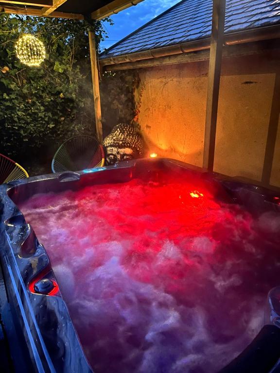 un bain à remous rempli de fumée rouge et violette dans l'établissement Maison La Glycine, à Chamoux-sur-Gelon
